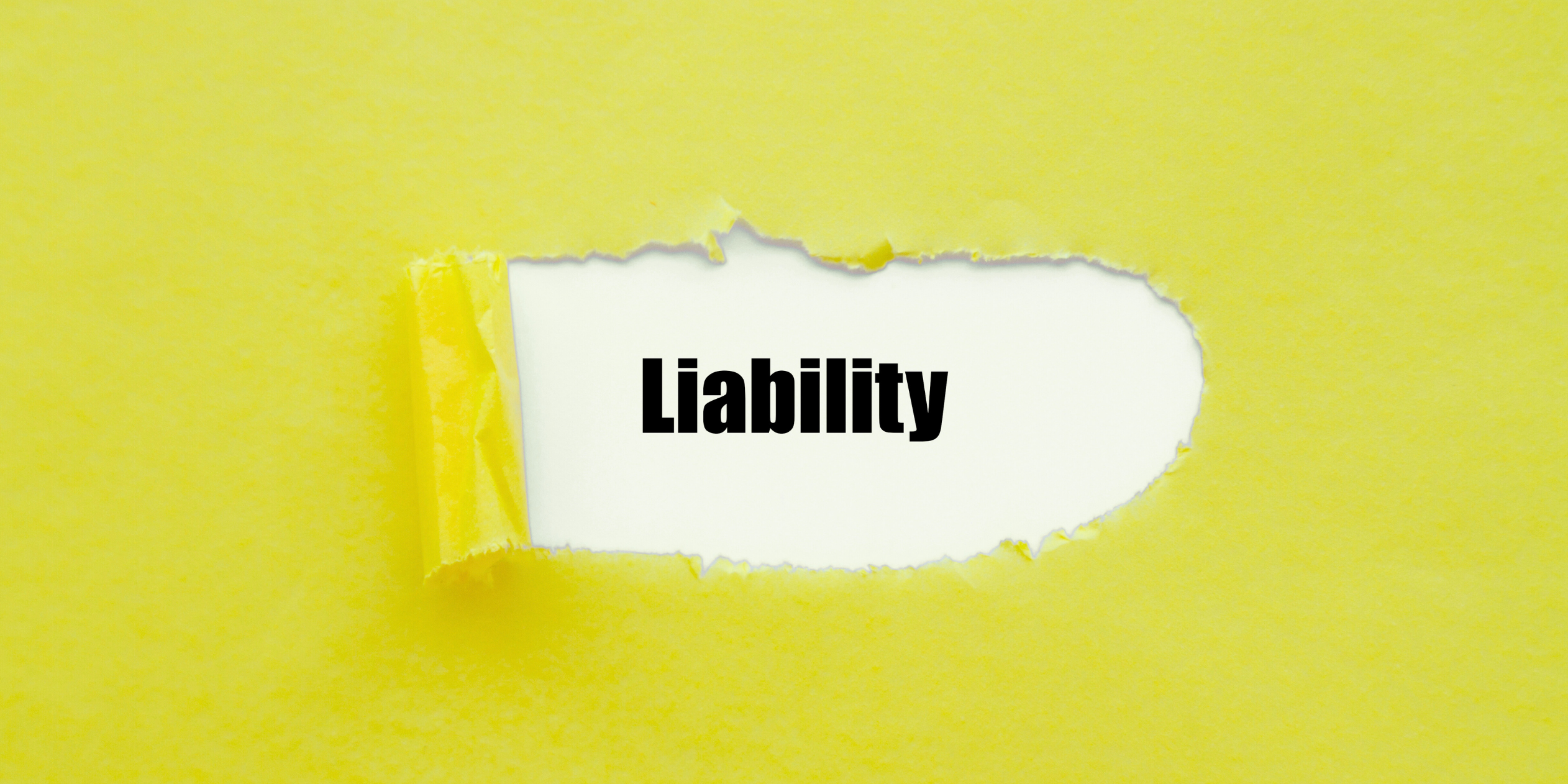 The word "Liability" is revealed beneath a torn section of bright yellow paper, symbolizing uncovering hidden or underlying issues.